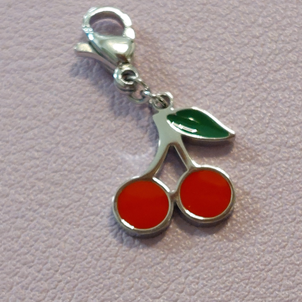 charm ou breloque avec un petit fermoir pour ajouter à un collier où à un bracelet en accumulation personnalisé. il represente une paire de cerise bien rouges et leur petite feuille de couleur verte en acier inoxydable sur carry le rouet