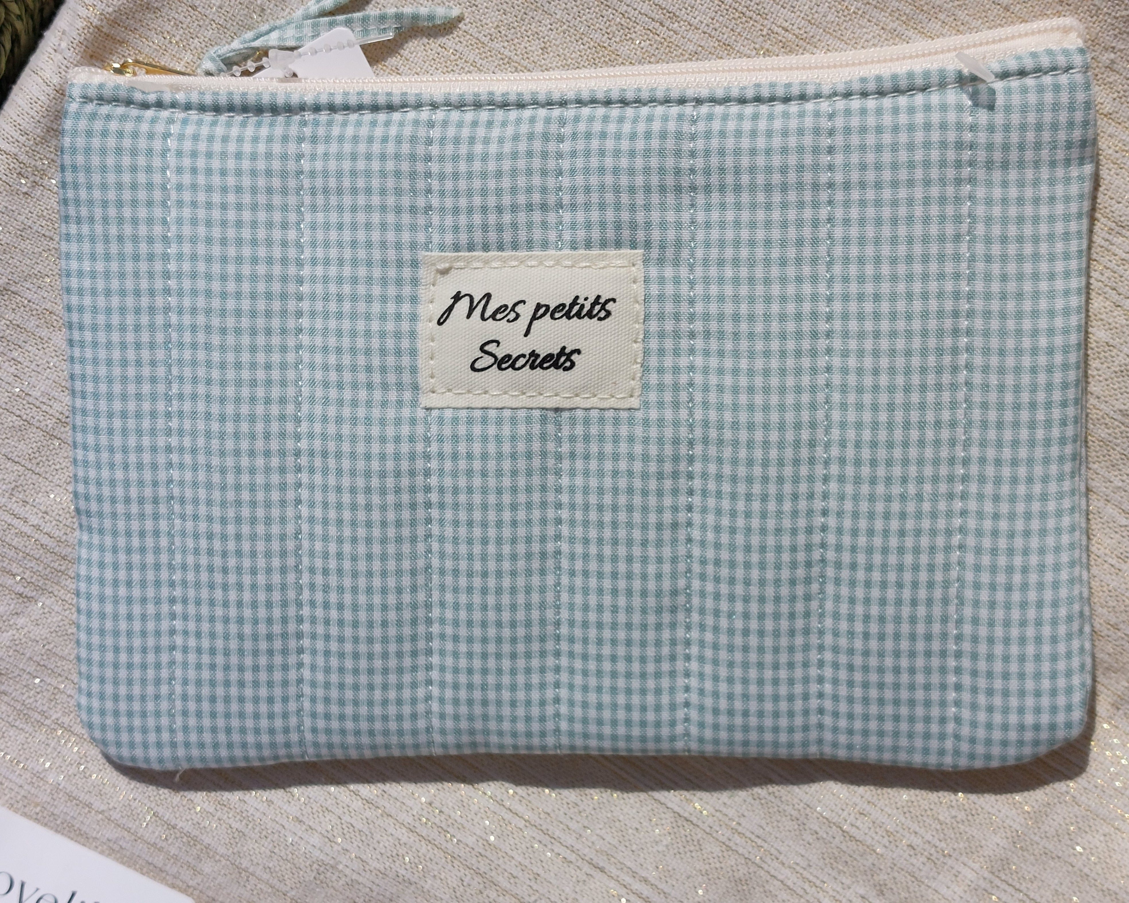 pochette en tissu matelasse de 20 cm sur 14 cm imprime vichy vert et blanc avec messge mes petits secrets sur une face. fermeture zip sur le dessus