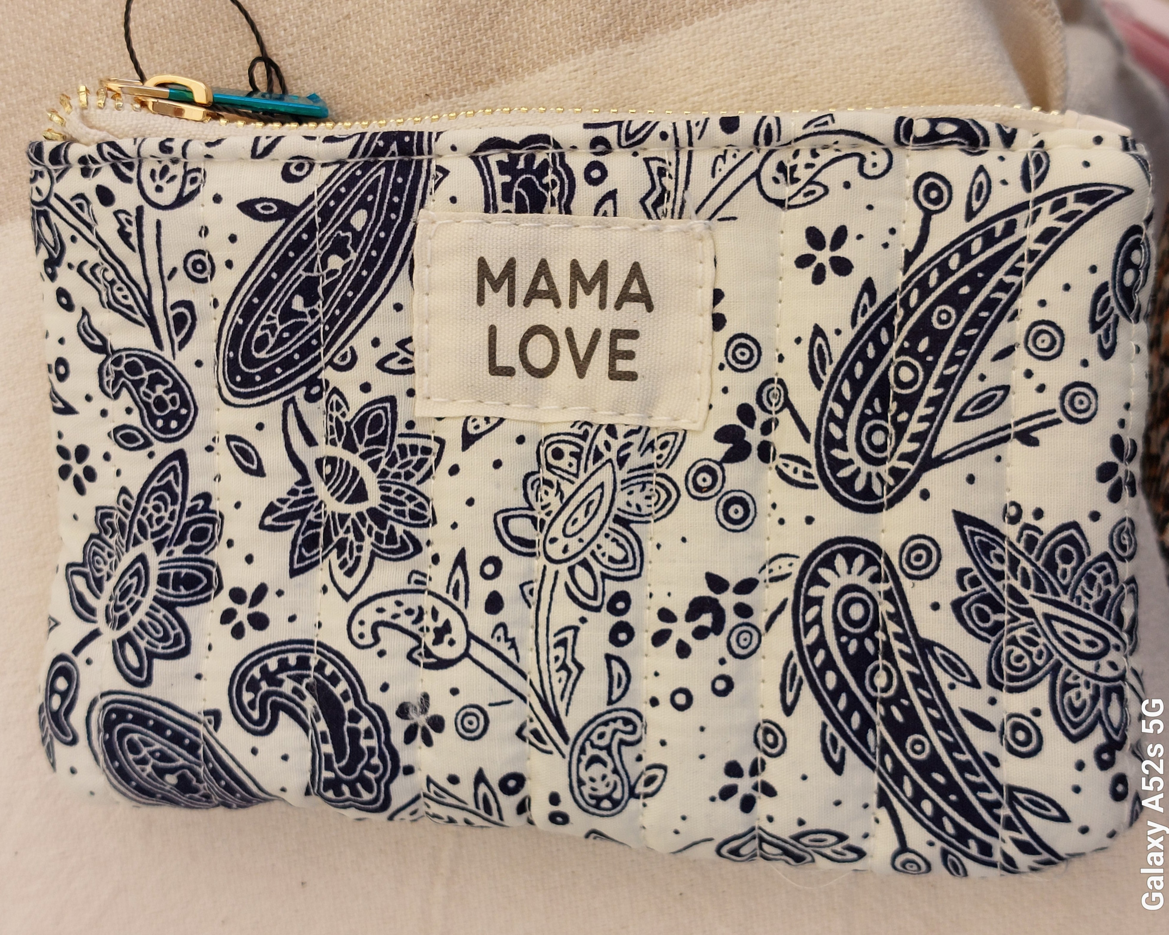 Mini pochette en tissu matelasse de 16 cm sur 10 cm imprime cachemir marine et blanc avec message mama love sur une face. fermeture zip sur le dessus