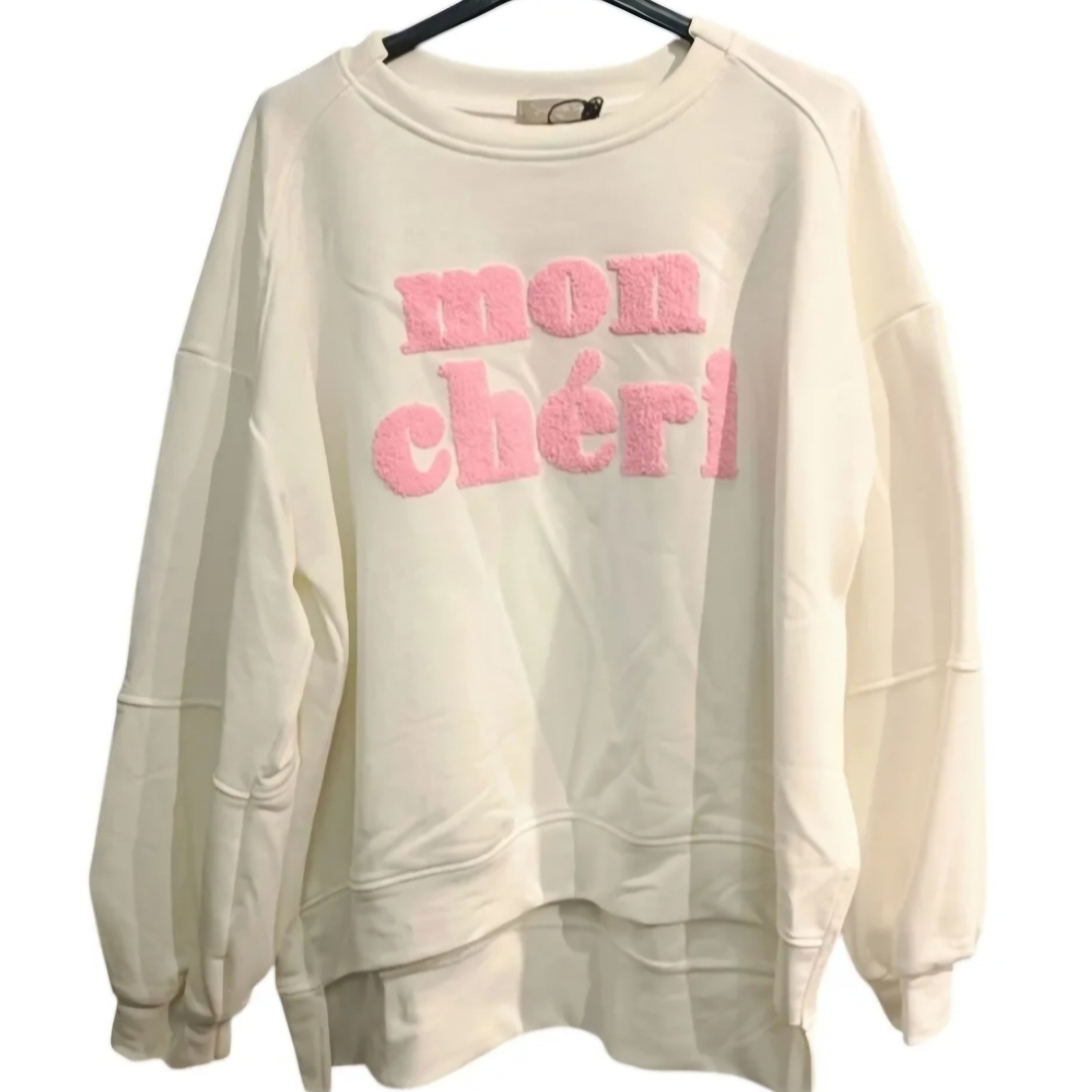 Sweat manches longues finis par un poigné a bord cotelé et porté par un mannequin sur un jean. col rond et l'on voit devant une grosse incription MON CHERI en bouclette rose sur Sausset les pins