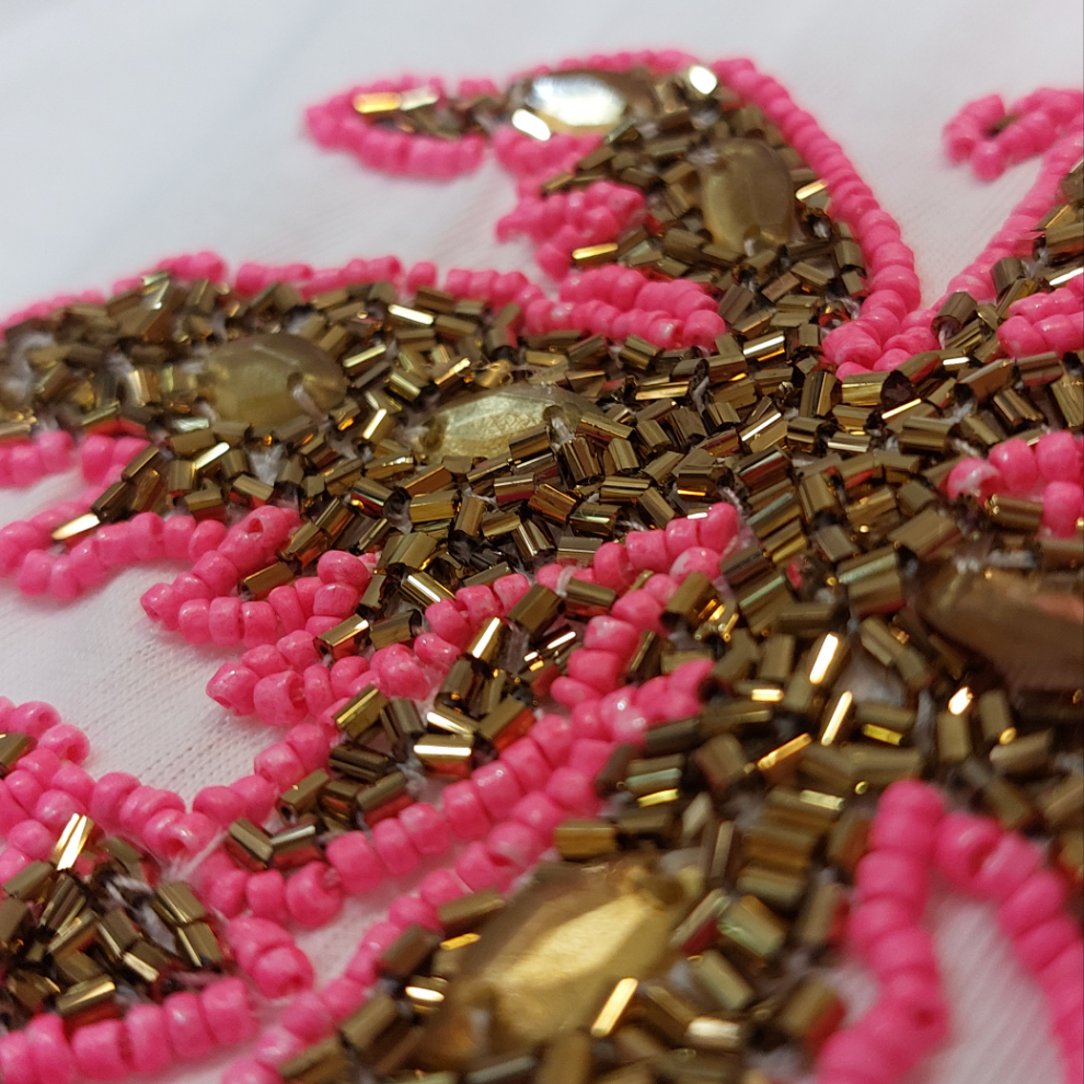 detail broderie en perle rose et doré représentant un palmier sur ensues la redonne