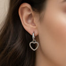 Femme portant les boucles d’oreilles Le Cap créoles acier inoxydable avec pampilles cœur