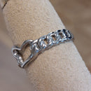Bague Belo vue de côté - détail maillons et cœur ajouré acier argenté
