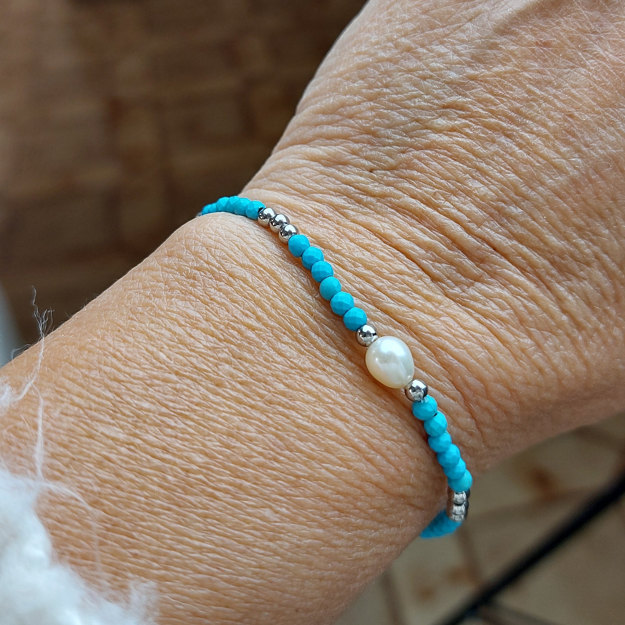 bracelet perles aciers perles  turquoises et une perle blanche pour tous les poignés car élastiqué sur carry le rouet