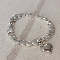 Bracelet élastiqué constitué de perles aciers en forme de petits coeurs bombés et fini par une pampille aussi en forme de coeur bubble sur sausset les pins