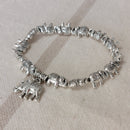 Bracelet élastiqué constitué de perles aciers en forme de petits éléphants et fini par une pampille aussi en forme d'éléphant sur carry le rouet