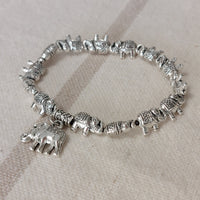 Bracelet élastiqué constitué de perles aciers en forme de petits éléphants et fini par une pampille aussi en forme d'éléphant sur carry le rouet