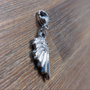 charm ou breloque avec un petit fermoir pour ajouter à un collier où à un bracelet en accumulation personnalisé. il represente une aile en acier inoxydable sur carry le rouet