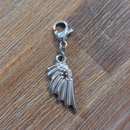 charm ou breloque avec un petit fermoir pour ajouter à un collier où à un bracelet en accumulation personnalisé. il represente une aile argent en acier inoxydable sur aix en provence
