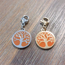 charm ou breloque avec un petit fermoir pour ajouter à un collier où à un bracelet en accumulation personnalisé. il represente une pastille ronde motif arbre de vie sur fond corail  doré et argent   en acier inoxydable sur aix en provence
