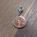 charm ou breloque avec un petit fermoir pour ajouter à un collier où à un bracelet en accumulation personnalisé. il represente une pastille ronde motif arbre de vie sur fond corail  argent   en acier inoxydable sur marignane
