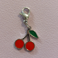 charm ou breloque avec un petit fermoir pour ajouter à un collier où à un bracelet en accumulation personnalisé. il represente une paire de cerise colorées en acier inoxydable sur marignane
