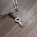 charm ou breloque avec un petit fermoir  ajouter un bracelet anneaux rectangle argent accumulation personnalisé. il represente une petite clé  argent  en acier inoxydable sur aix en provence