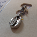 charm ou breloque avec un petit fermoir pour ajouter à un collier où à un bracelet en accumulation personnalisé. il represente un coqillage en acier inoxydable sur carry le rouet