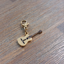 charm ou breloque avec un petit fermoir pour ajouter à un collier où à un bracelet en accumulation personnalisé. il represente une guitare dorée en acier inoxydable sur carry le rouet