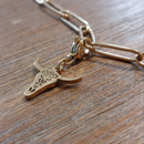 charm ou breloque avec un petit fermoir pour ajouter à un collier où à un bracelet en accumulation personnalisé. il represente une tete de buffle ajourée et dorée en acier inoxydable sur martgues