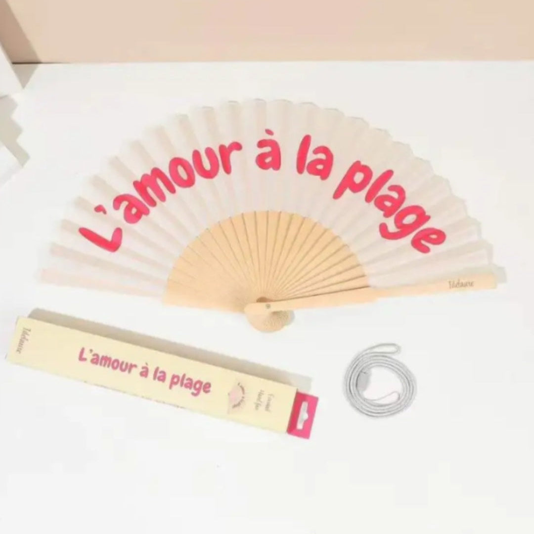 Éventail Abanito ouvert message L'amour à la plage – col écru, porté en bandoulière