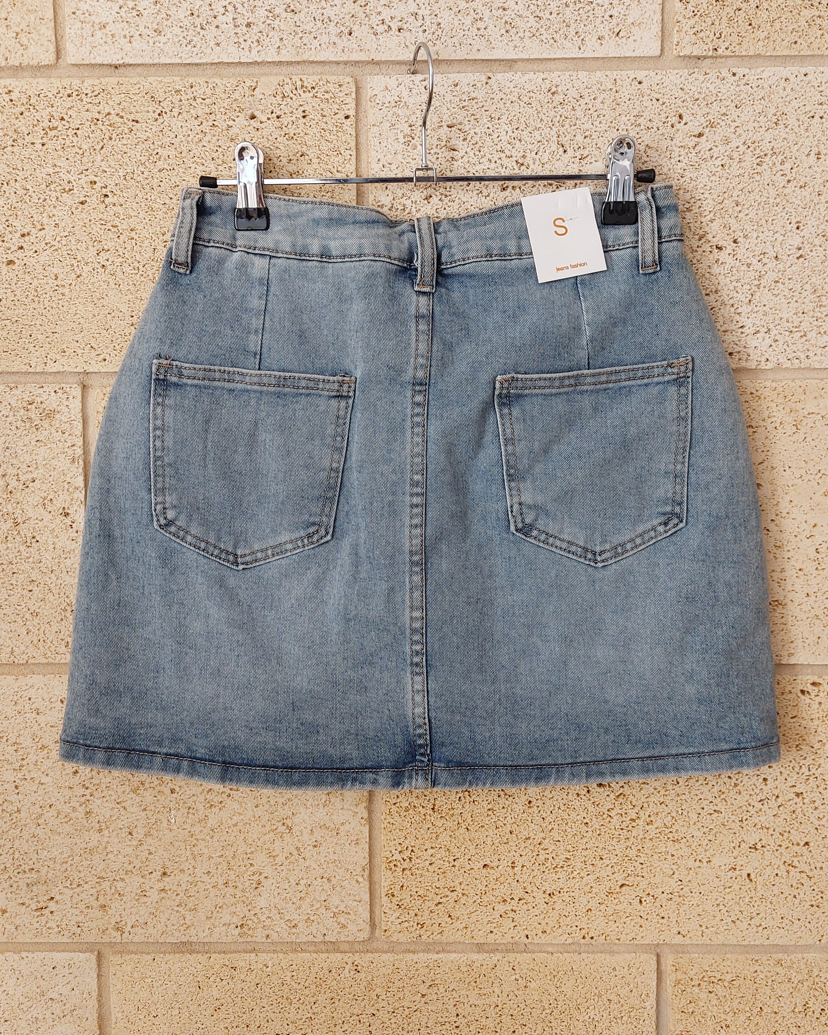 Jupe-short jean Deso dos – deux poches arrière denim délavé clair, finition ourlet brut, étiquette taille S Made in Italy
