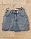 Jupe-short jean Deso face – mini portefeuille denim délavé clair, bouton zip, poches avant, ourlet brut effiloché
