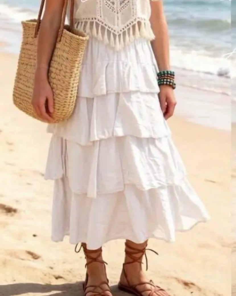 Jupe longue Emma blanche portée avec sandales à lacets sur une plage de sable — voile coton volants taille élastique — look bohème chic été — ineva
