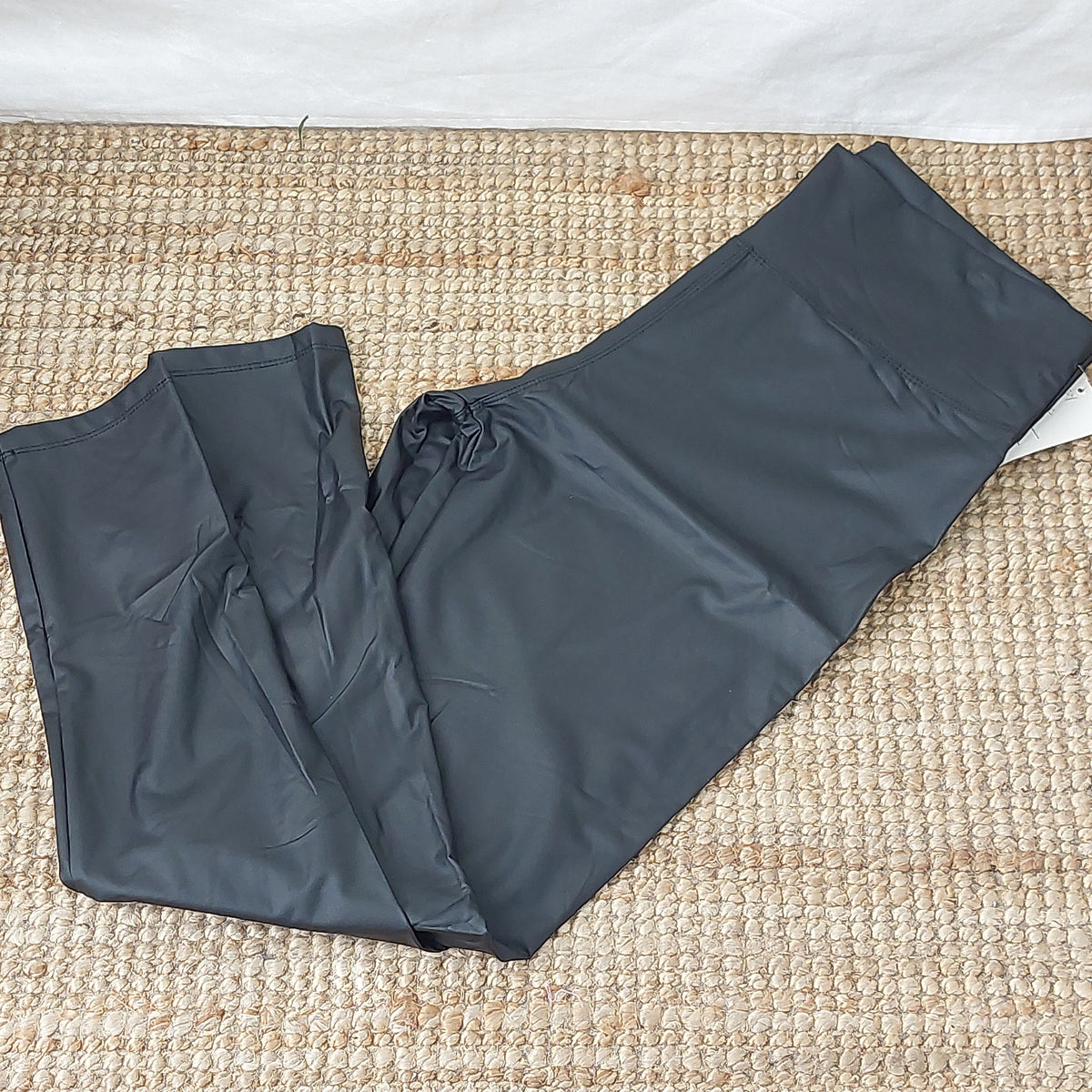 Legging grande taille Santa noir en simili cuir brillant, présenté à plat avec les jambes repliées
