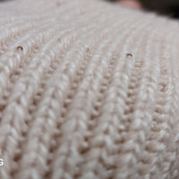 Détail des sequins délicats sur les mitaines longues Lume en maille serrée