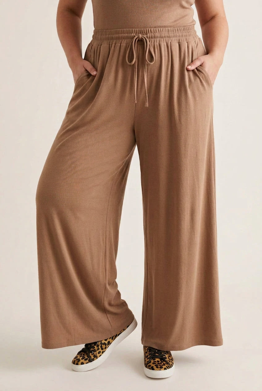 Pantalon grande taille Marlo camel porté de face avec des baskets léopard, coupe large à jambes droites
