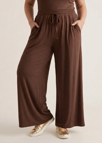 Pantalon grande taille Marlo choco porté de face, coupe large et taille élastiquée, avec les mains dans les poches
