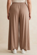 Pantalon grande taille Marlo camel porté de dos, taille élastiquée et jambes larges droites
