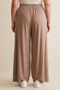 Pantalon grande taille Marlo camel porté de dos, taille élastiquée et jambes larges droites
