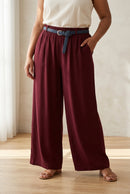 Pantalon large Remi bordeaux porté de face, taille élastiquée avec ceinture et jambes droites
