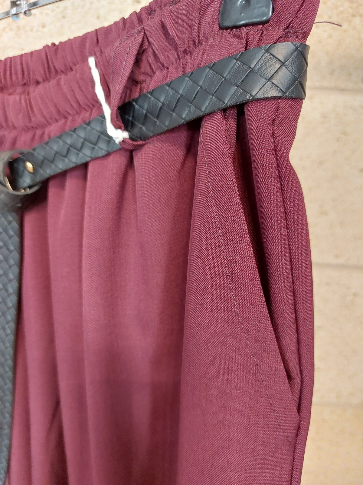 Détail de la poche latérale, de la taille élastiquée et de la ceinture tressée du pantalon Remi bordeaux
