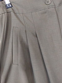 Détail des pinces et de la fausse poche du pantalon palazzo Lois kaki, porté avec des baskets
