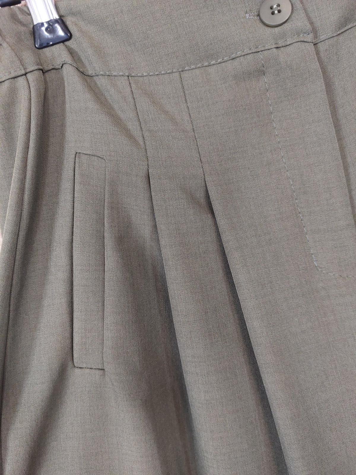Détail des pinces et de la fausse poche du pantalon palazzo Lois kaki, porté avec des baskets

