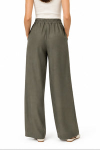 Pantalon palazzo Lois noir porté avec des baskets, made in Italy
