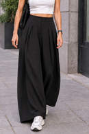 Pantalon palazzo Lois noir porté avec des baskets, made in Italy
