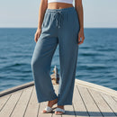 Pantalon Roman en gaze de coton coloris bleu jean, il est élastiqué à la taille et de coupe large pour la jambe sur sausset les pins