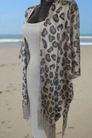paréo en filet brillant et extensible coupe poncho ouvert devant et finition franges sur le bas. celui ci est porté sur une jupe et un crop top mais il peut aussi etre porté sur un maillot de bain. coloris argent brillant sur carry le rouet