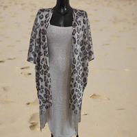 paréo en filet brillant imprimé léopard et extensible coupe poncho ouvert devant et finition franges sur le bas. celui ci est porté sur une jupe et un crop top mais il peut aussi etre porté sur un maillot de bain. coloris or brillant sur carry le rouet