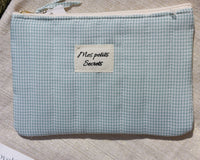 pochette en tissu matelasse de 20 cm sur 14 cm imprime vichy vert et blanc avec messge mes petits secrets sur une face. fermeture zip sur le dessus