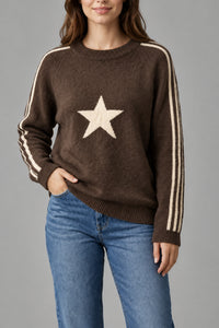 Pull Noel taupe porté, col rond, étoile devant et bandes blanches sur les manches
