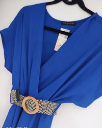 robe longue unie coloris bleu royal et joliement ceinturée en beige sur ceintre. le haut de la robe a une forme kimono et le bas est ample avec du mouvement  sur carry le rouet