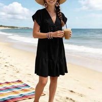 Robe col V Bellac noire portée sur la plage — coupe ample volants cascade mancherons — look estival élégant — ineva
