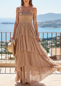Robe longue bohème Evola camel portée en bord de mer avec chapeau de paille — bustier smocké, volants étagés en voile coton fluide, Made in Italy — ineva
