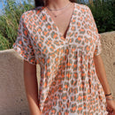 Robe en gaz de coton imprimé léopard dans le kaki/orange, elle a un col V et une couture sous poitrine non serrée, robe ample manche courte forme kimono sur carry le rouet 