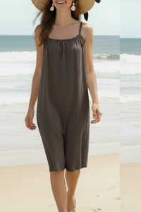 Robe courte Xian choco portée sur la plage avec chapeau de paille — encolure droite froncée, bretelles fines, coupe ample, viscose fluide, taille unique 36/44, Made in Italy — ineva
