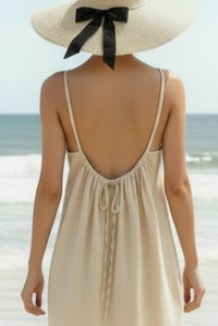 Robe courte Xian portée de dos sur la plage — dos nu avec cordon de serrage réglable, bretelles fines, viscose fluide, Made in Italy — ineva

