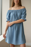Robe courte Zoé lyocell aspect jean portée par une jeune femme en version épaules Marilyn — col large élastique — look glamour casual chic — ineva
