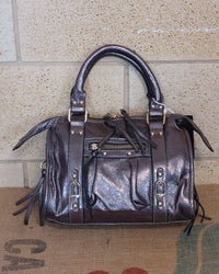 Sac Azilal simili cuir brillant métallisé bronze vue de face — forme bowling, double poignée courte, poche zip frontale, clous et boucles dorés, 28x20 cm — ineva

