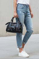 Sac Azilal simili cuir brillant métallisé noir porté à la main — forme bowling, double poignée courte, bandoulière amovible, clous et boucles dorés, 28x20 cm — ineva
